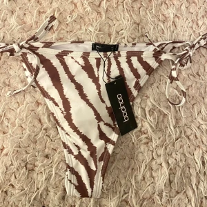 Bikini  - Bikini underdel i tiger randig brun färg🤍🤎 Som sprillans ny, med prislapp kvar 🫶🏼Går att anpassa storleken i midjan, knyt åt mer eller mindre 🎀