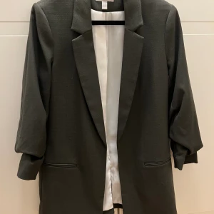 Kavaj - Grön kavaj strl S. Använd vid ett tillfälle. Mycket gott skick.