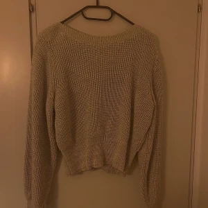 Grå stickad tröja - En grå stickad tröja med ballongärmar. Normal lång och i gott skick.