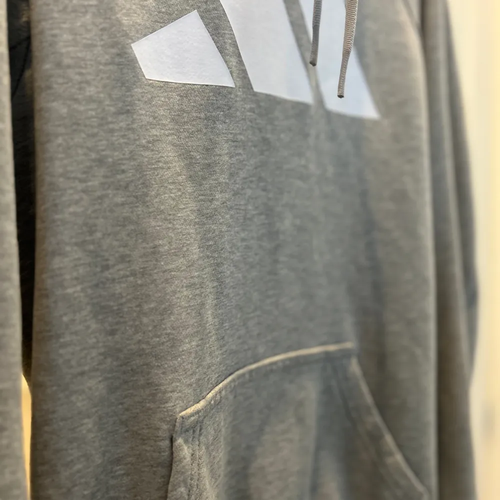 En grå fin adidas hoddie med luva och fickor och luva som då är i storlek S. Äkta adidas hoddie och är använd 1-2 gånger. Mycket bra skick!!. Hupparit & Collegepaidat.
