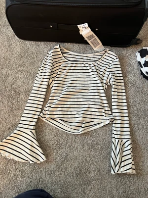 Randig tröja med volangärm  - Fin långärmad tröja med utsvängd ärm. Aldrig använd 