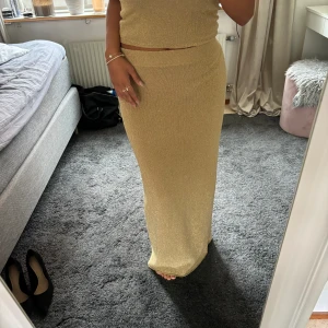 Guldig kjol - Guldig kjol från Gina Tricot i storlek L. Använt endast 1 gång då den tyvärr är lite stor på mig. Säljer även toppen till men separat ifall man inte vill ha båda