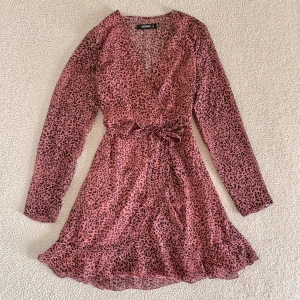Missguided grisrosa leopardklänning - Väldigt fin klänning från Missguided med volanger och knytning i midjan. Aldrig använd. Väldigt bekväm och avslappnad passform. Utan anmärkningar. 