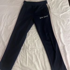 Palm Angels track pants  - Köpte den från Kaspersheat 2022. Kom inte ofta till användning så jag bestämde mig för att sälja den.   Navy blue med guldiga stripes. Byxan är i storlek M och i väldigt bra skick.