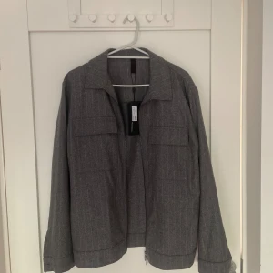 Grå Overshirt från J Lindberg i storlek M för 499kr - Ny och oanvänd J Lindberg Obershirt. Normal passform, Storlek M. Tveka inte att höra av dig vid intresse eller eventuella frågor!