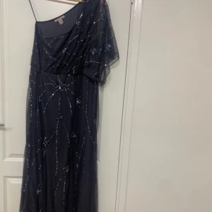 Klänning  - Mörkblå lång festklänning i storlek 44. Half one shoulder klänning. Använd 1 gång.   Pris: 1000   Skicka meddelande om du vill ha flera bilder på klänningen. Kan mötas i Södertälje eller så kan klänningen fraktas. Priset kan diskuteras.