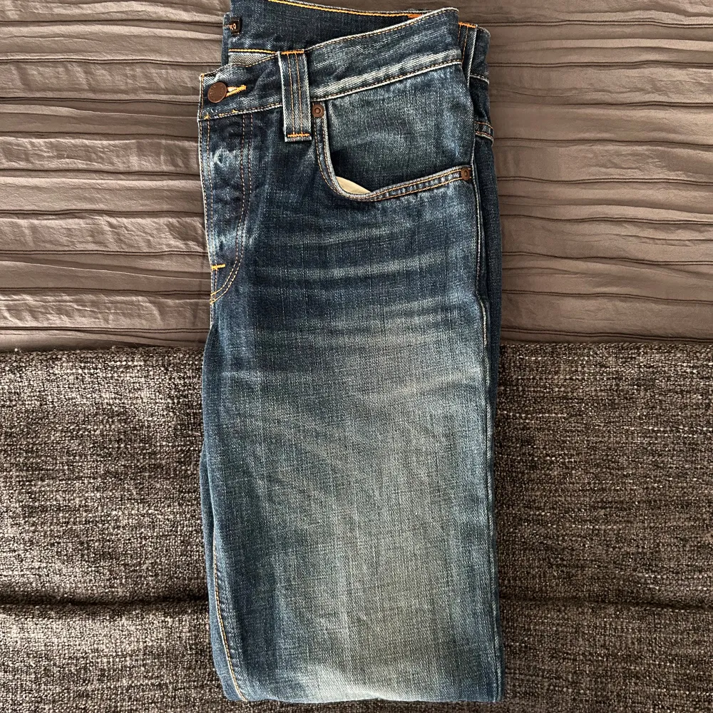 Blåa Nudie Grim Tims i felfritt skick! Storlek 31/34, men är kortare i längden och sitter som 31/32. Nypris runt 1500kr!. Jeans & Byxor.