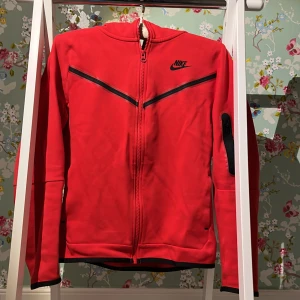 röd nike tech fleece zip hoodie - Har bara använda några gånger med inga skador på plagget är är som ny. Pris: 399 plus frakt. Priset kan diskuteras. Ny pris ca 1100