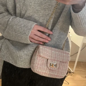Väska i bouclé - Liten rosa väska i bouclé från Kappahl, nypris 180kr. Knappt använd, denna färg går inte att köpa längre. Köpare står för frakt.