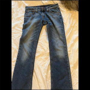 Blåa bootcut jeans  - Skit snygga bootcut jeans med blå tvätt! Köpte av en jättesöt tjej på loppis men har aldrig använt dem själv då dem var lite för stora. Inga defekter förutom slitningarna i follen. Skriv gärna om ni har frågor 💕.