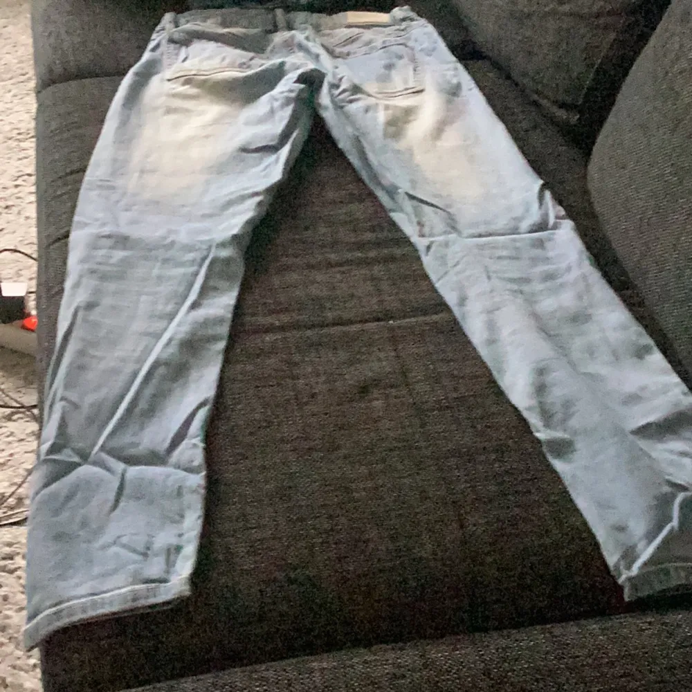 Säljer ett par ljusa jeans med massor av slitningar och hål. De är riktigt coola och har en avslappnad stil. Perfekta för en casual look! De är i bra skick trots slitningarna, som är en del av designen.. Jeans & Byxor.