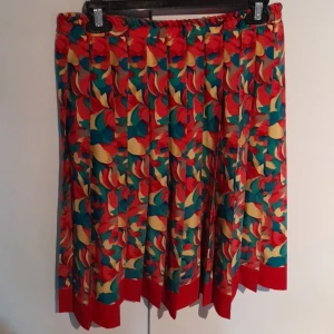 Färgglad veckad kjol - En färgglad veckad kjol, går ner till knäna. Storlek L men passar M/XL också.