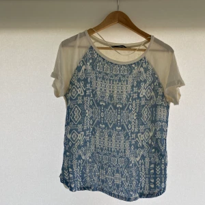 Mönstrad topp från KappAhl - Säljer en snygg blåvit topp från KappAhl i storlek M. Perfekt för sommaren. Obs!! finns fläck på baksidan (se slide 5). Hör av er vid eventuella frågor!!