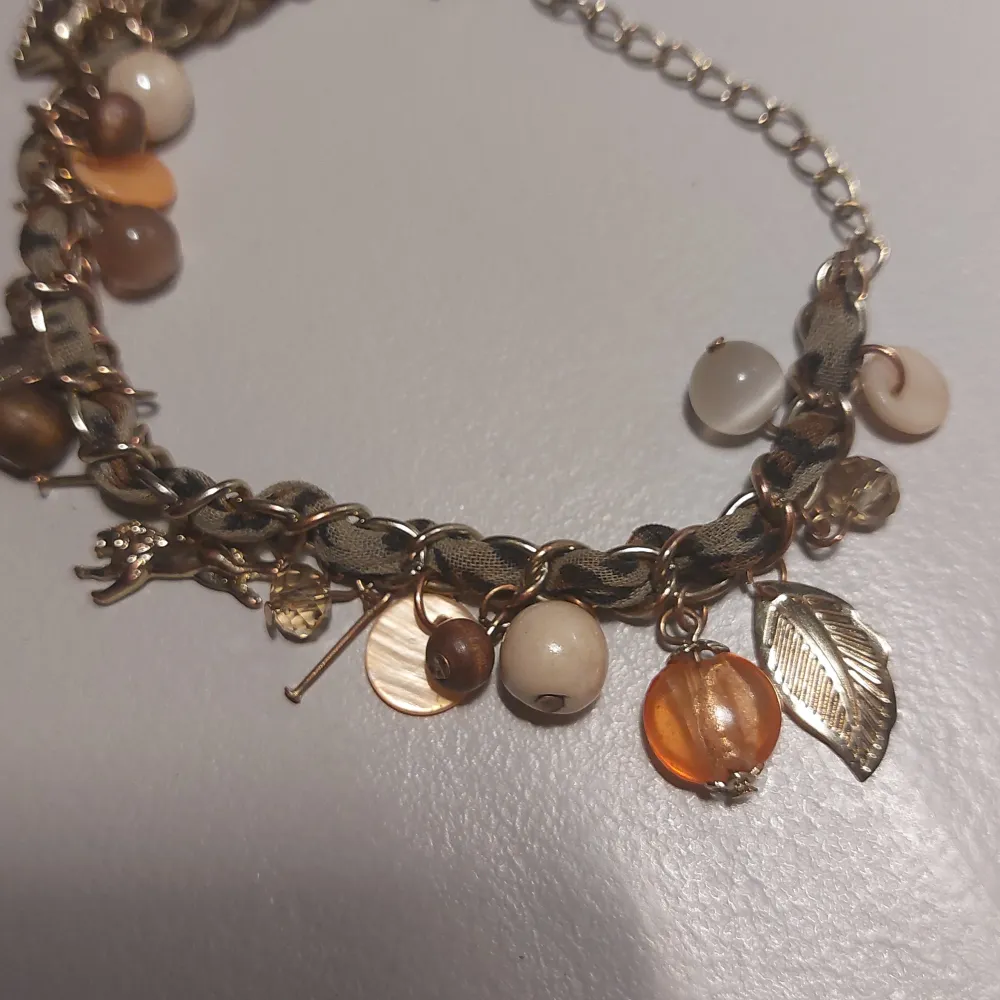 Gulligt armband med pärlor och berlocker i guld. . Asusteet.