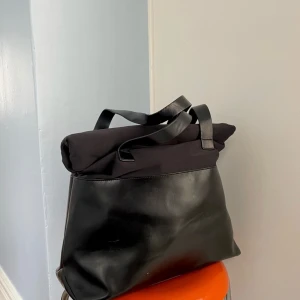 Väska stories - Väska stories, jättefin och rymlig skolväska som får plats med dator, block  med mera. Öppningen rullas ihop och stängs med magnetlås. Använd men i gott skick, se bilderna! Säljes därför billigt