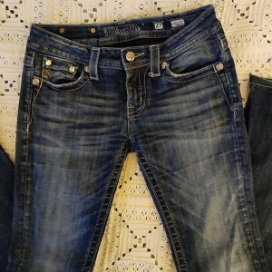 Blå jeans från Miss Me - Säljer ett par Miss Me  jeans som jag köpte på loppis men som tyvärr var för korta för mig som är 170 lång💗💗 Dem är bootcut och ser helt nya ut förutom lite skav längst ner.