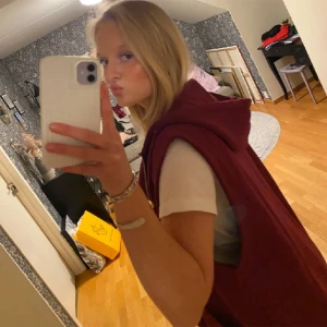 Vinröd väst med dragkedja och huva - Säljer en snygg vinröd väst med dragkedja och huva. Västen är perfekt för höst och vår, och den har en oversized passform. Den är gjord av bomull och polyester, vilket gör den både bekväm och hållbar. Perfekt för en avslappnad stil eller för att lägga till ett extra lager värme.