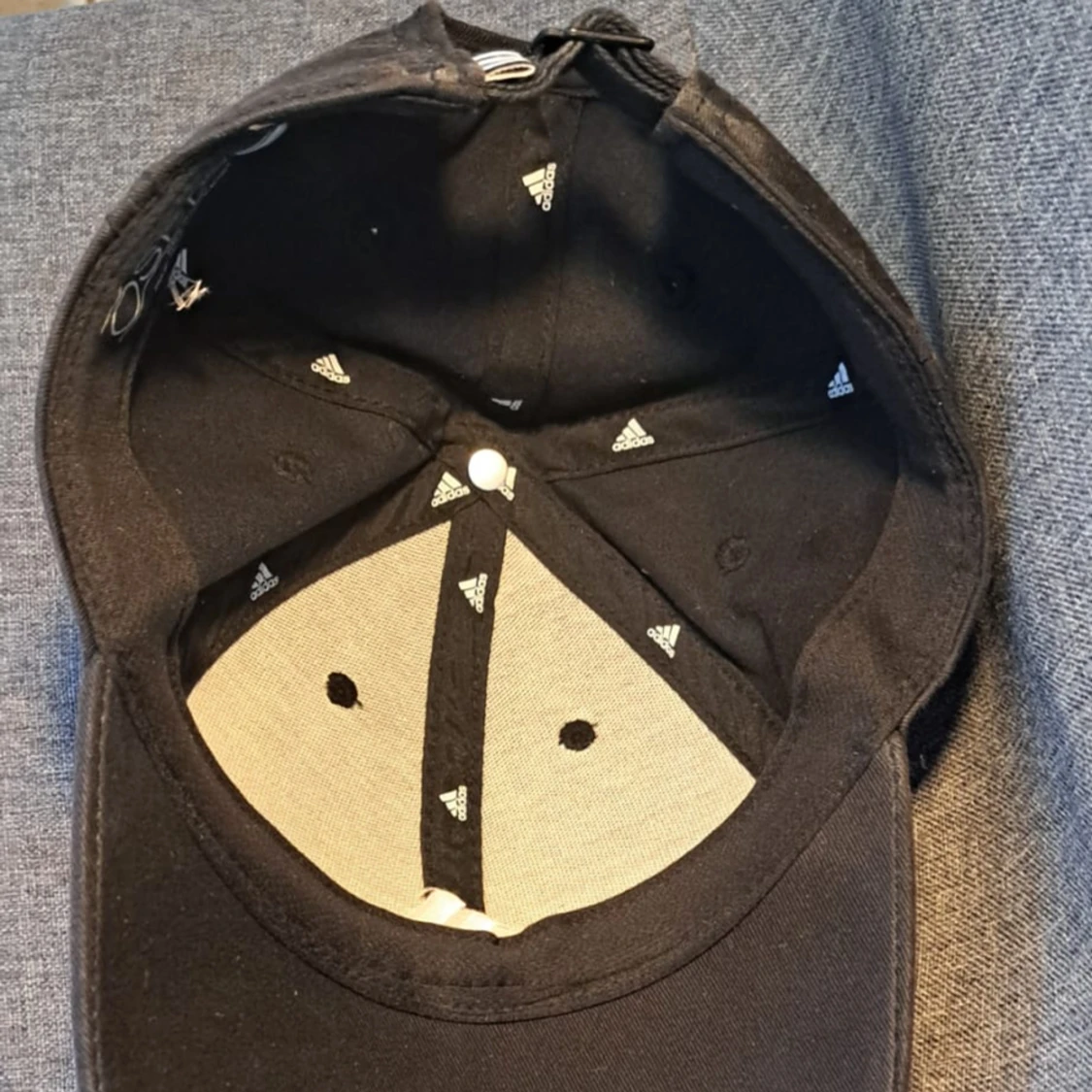 En svart adidas keps med vitt adidas märke och ränder. - 92