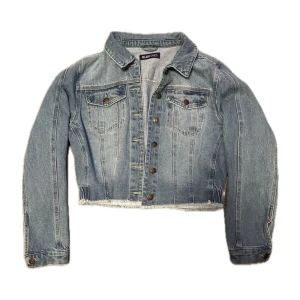 Jeansjacka  - Blå croppad jeansjacka, resår där bak. Använd fåtal gånger, i bra skick. 