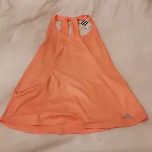Orange tränings linne i märket Adidas Storl S Katt finns i hemmet 
