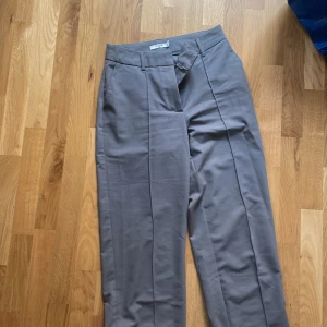 Gråa kostymbyxor  - Grå högmidjade kostymbyxor. 