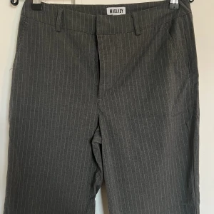 Grå randiga kostymbyxor  - Ett par grå randiga kostymbyxor från Madlady. Dessa är aldrig använda så i helt nytt skick. I ”short” modell i stl 36. 
