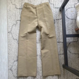 Vintage Kostymbyxor - I bra skick med en liten fläck som syns på sista foto  40cm över midjan och 100cm totalt i längs. Vädligt snygga med en rak passform!.Skriv ifall du har några fler frågor!