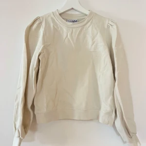 Sweater från Ganni - Creme-färgad sweater från Ganni med logo på bröstet och puffärm 🤍 Nypris: 1795, Mitt pris: 399 kr