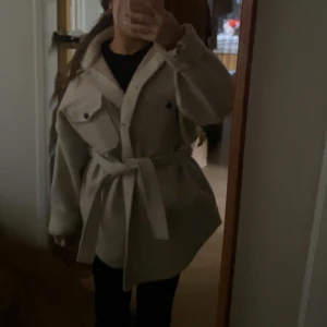 Nelly kappa - Säljer denna fina beigea kappa från Nelly i storlek 36. Nypris 850kr men säljer den för 165kr. En aning för stor för mig som är 158cm lång.