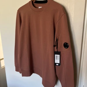 C.P Company diagonal fleece SS22 BNWT - Köpte denna på tradera och den var för stor. Har kört en Certilogo så att man kan se att den är äkta. BNWT. Finns inget kvitto då den vanns i en budgivning. Snygg färg lite rostbrun/tegel. Pris kan diskuteras. Byten är också intressant.