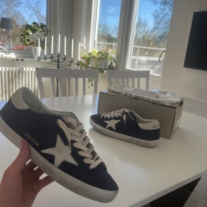 Golden goose superstar - Mörkblå mocka golden goose i storlek 43. Skorna är köpta på kicksnstuff och är helt oanvända! Just denna färg är väldigt svår att få tag på. Såklart äkta. Ange gärna prisförslag och jag är öppen för byten mot flycrews i bra skick! Skriv om det är nåt