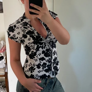 Blommig blus med knytning  - Jag säljer denna underbara blommiga blus med knytning i ryggen i storlek 10 (M, *justerbar storlek). Toppen är i mycket bra skick & har inga synliga defekter. Pris kan diskuteras. Lägg ett prisförslag eller köp direkt. Hmu om du har andra frågor.💞
