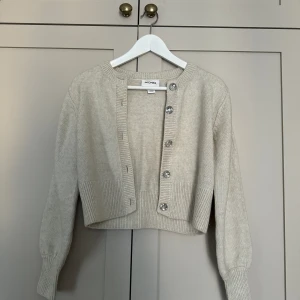 Knappkofta🤍 - Beige, stickad knappkofta med stenar från Monki🤍Är i nyskick, då den aldrig har kommit till användning. Kan till exempel matchas med ett vitt linne😍