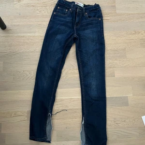 Lågmidjade Levis jeans  - Ett par Levis jeans som jag klippt upp en slits på ( köpta i barnstolen men med mycket stretch) skulle säga att det är storlek xs 