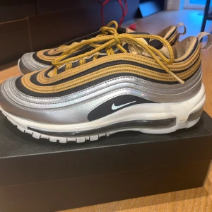 Nike Air Max 97 - Nike Air Max 97 i silver/guld. Använd 1 gång, i superbra skick. Storlek 38.5