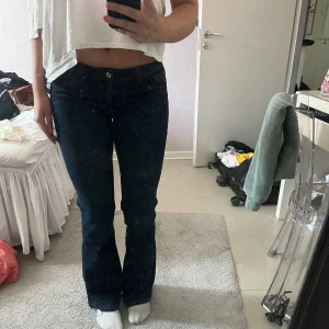 Low bootcut jeans  - Supersnygga mörkblåa jeans, ser nästan svarta ut på bilden, från hm som inte går att köpa längre! Så fina detaljer på bakfickorna!! Köpte dom i London för 250 kr. Uppsprättade längst ner för att dom ska gå ner till marken på mig som är 173 cm lång🩷🩷