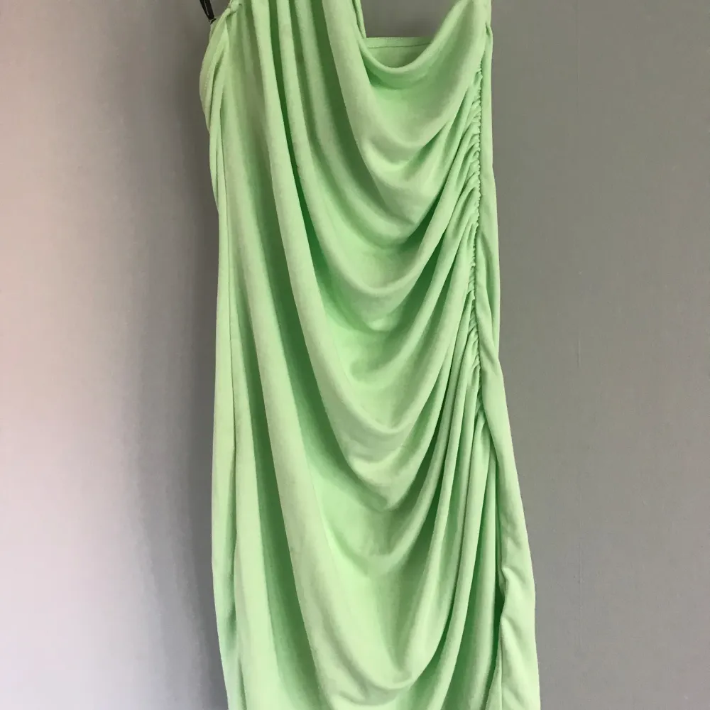 Ny neon grön klänning med tight passform kring höfter och vid bysten De formar och skapar en hourglass figure. Mekot.