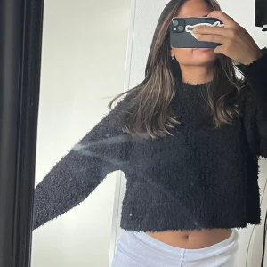 Stickad teöja - En lurvig svart tröja knappt använd