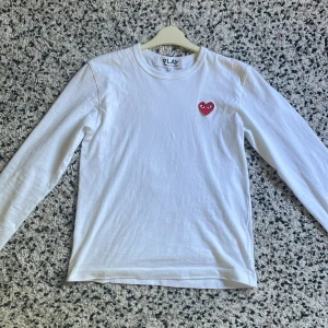 CDG långärmad t-shirt - Långärmad t-shirt från Comme des Garcons i gott skick (9/10). Köpt på NK i Stockholm (kvitto finns). Nypris: 949 kr. Hör av dig vid frågor. Pris går att diskutera.
