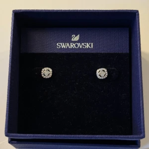 SWAROVSKI ÖRHÄNGEN  - ”Swarovski Angelic Stud earrings square cut” Lika som de på bild 2, men dessa är helt silver. Helt oanvända. Prislapp, äkthetsbevis, ask och påse medföljer. Säljs inte längre. Nypris ca 850kr. Mitt pris 500kr, kan diskuteras 🩵