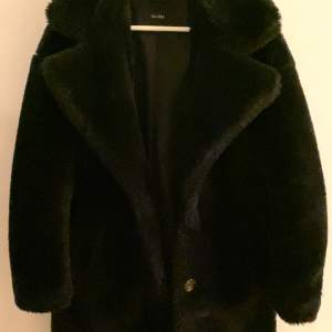 En svart fluffig päls kappa från BERSHKA med knappar och krage köpt för 600