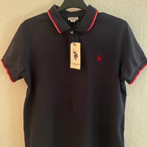 Polo T-Shirt - Levla upp stilen med en Polo pike t-shirt. Den är helt ny och oanvänd, utan bara testade en gång. Nypris ligger på runt 1000kr+(kvitto finns), mitt pris är 350. Fråga ifall du undrar något.
