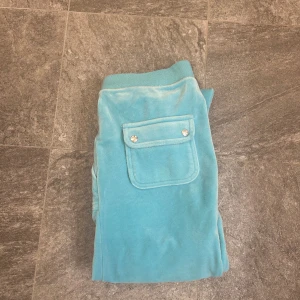 Juicy Couture byxor - Ett par turkosa juicybyxor i storlek M, ganska använt men det syns typ bara på knäna, nypris 1100kr. Köpt är köpt och köpare står för frakt.