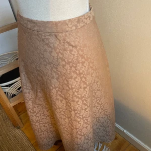 Kjol - Vackert mönstrad kjol med lite glans som lyxfaktor. Färg: Brun/brons