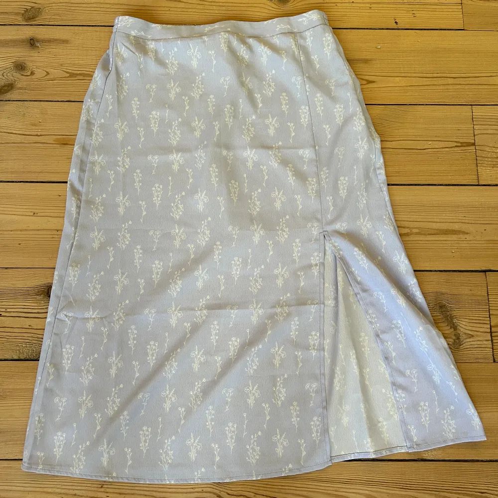 Säljer nu denna ljuslila kjol med blommönster som är köpt förra sommaren på veromoda💜, använd max 5 gånger. Midikjol med en slits vid benet🤍. Kjolar.