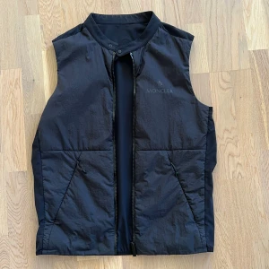 Moncler Beemin Padded Vest Black - Svart Moncler väst i size 2, köpt på NK 2023 för ca 7000kr, knappt använd och fortfarande i nyskick. Kan gå ned lite i pris vid snabb affär. Säljer pga för liten för mig. (SLUTSÅLD ÖVERALLT)