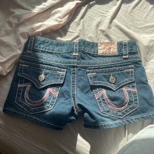 Lågmidjade True religion shorts - Jätte snygga true religion med röda och rosa detaljer i nyskick som jag köpte för någon vecka sen men dom var lite för tajta på mig . Därför säljer jag nu dessa. Kan gå ner i pris vid snabb affär💕