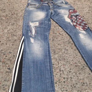 Homemade* adidas amstriped jeans with KISS rhinestones - 32/32   Homemade: distressing, rhinetones, adidas stripes sewn in    Condition 10/10 a tiny bit of heel bit    Pris inte hugget i sten (beror på snabb transaktion)
