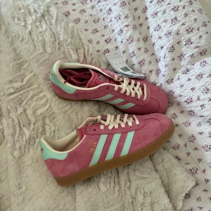 Adidas gazelle - BUDGIVNING PÅGÅR: högsta bud 1300kr! Budgivning avslutas onsdag kväll den 22/5! Skitnsygga Adidas Gazelle sneakers 🩷 helt nya, kommer med originalförpackning!☺️ 