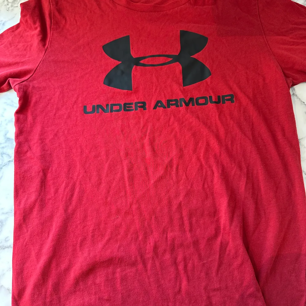 En röd under armour tröja i storlek XS. Tröjan har använts endast ett par gånger och ser ut precis som ny. Tröjan är luftig och relativt tunn och funkar därför perfekt att använda i sommarvädret. Tröjan känns även aningen större än XS. . T-shirts.